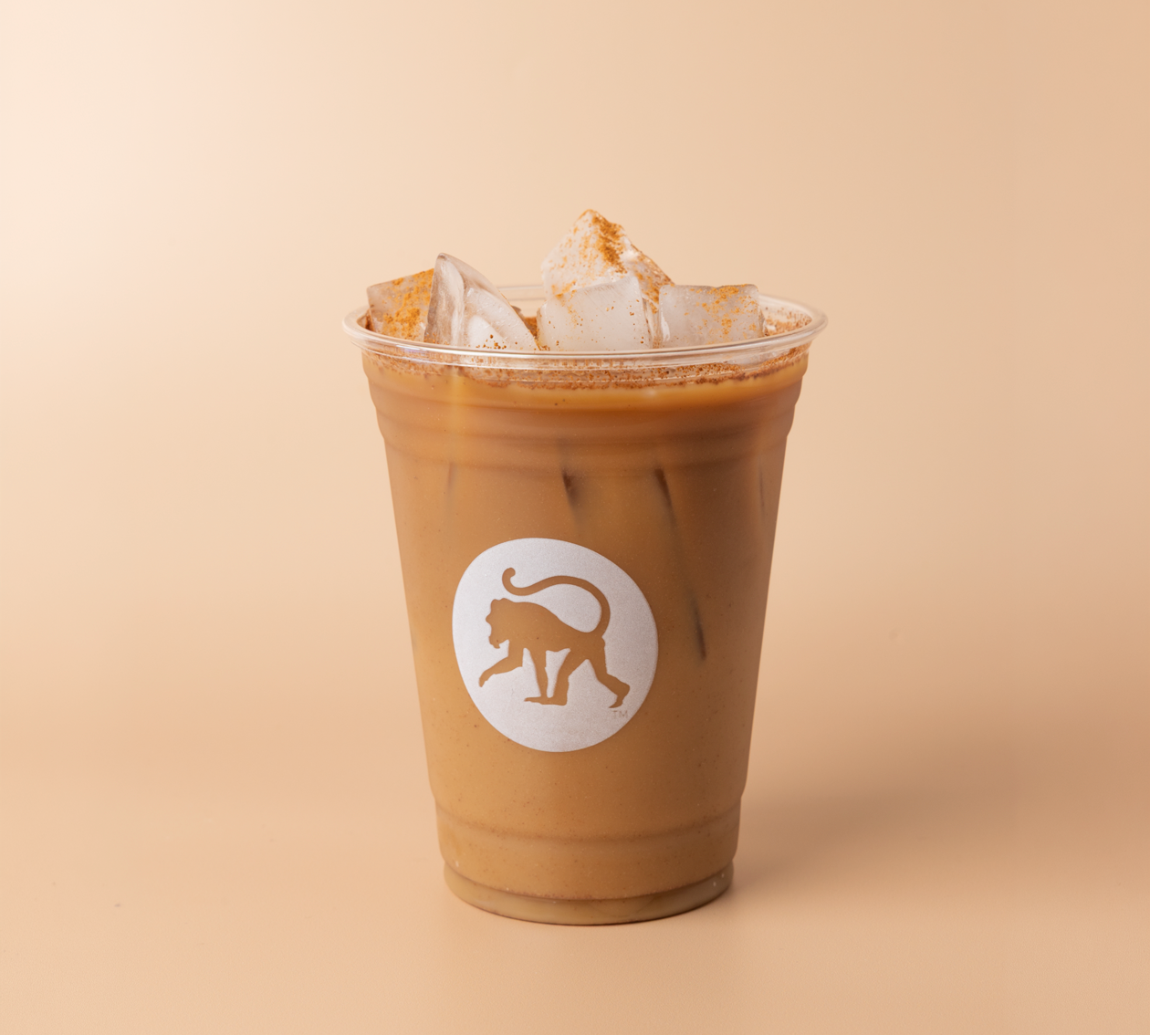 CinnaMonkey cold brew in a clear Frothy Monkey branded cup, cinnamon dusted over ice and cold foam on top.
