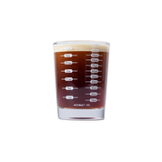 Measurement side of the shot glass, ounce and milliliter lines from 1/2 oz to 3 1/2 oz, filled with espresso.