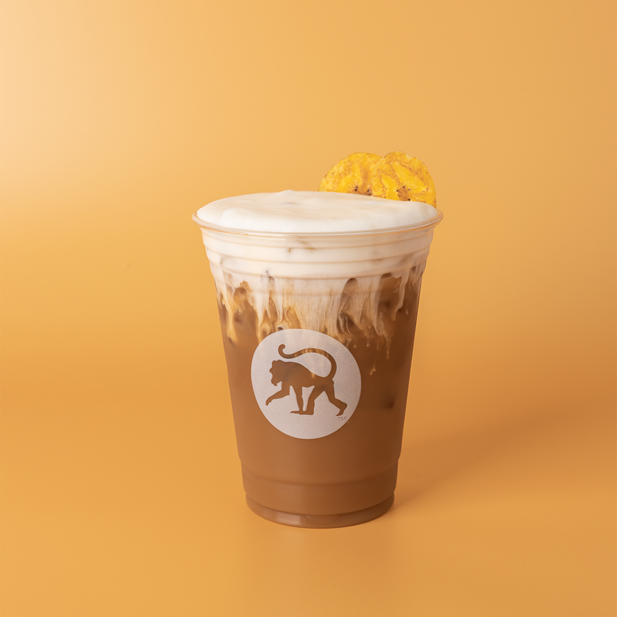 Banana puddin' cold brew in a Frothy Monkey branded cup, topped with vanilla cold foam and a vanilla wafer.