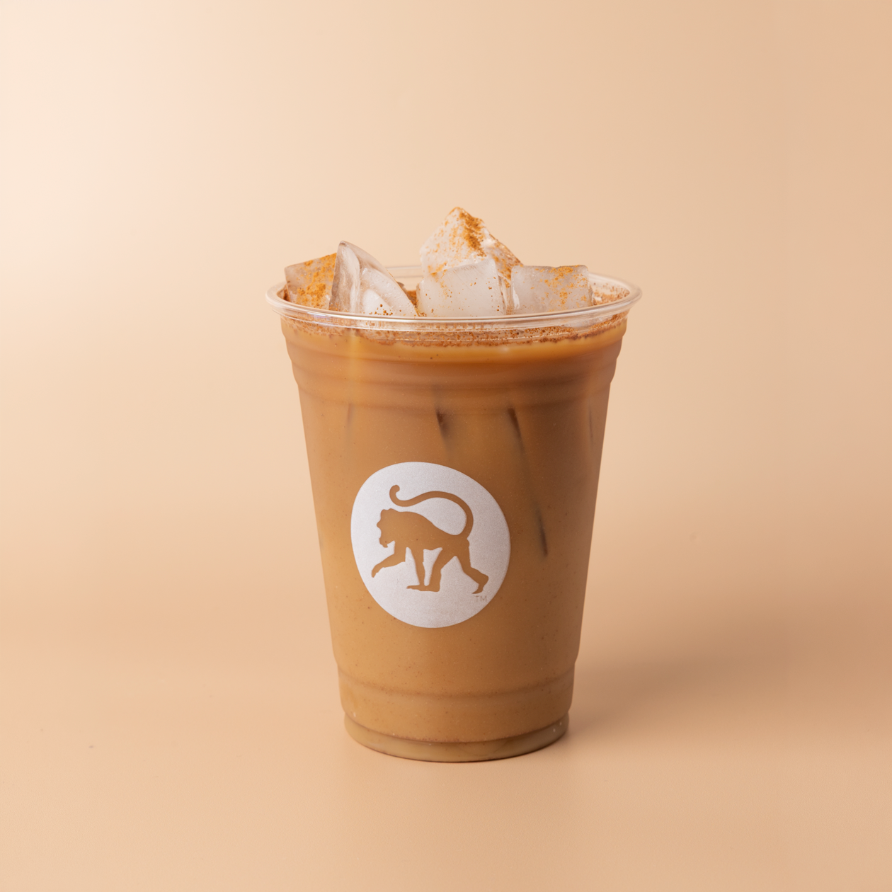 CinnaMonkey cold brew in a clear Frothy Monkey branded cup, cinnamon dusted over ice and cold foam on top.