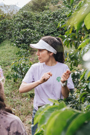 Carolina Ramirez talking with her hands raised mid-gesture in a coffee row at San Antonio farm, Andes, Antioquia, 1,850 MASL