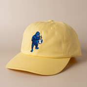 Banana yellow Frothy Monkey Kong dad hat shown at a three-quarter angle, low-profile unstructured crown and pre-curved visor with the navy and blue Kong coffee embroidery on the front panel