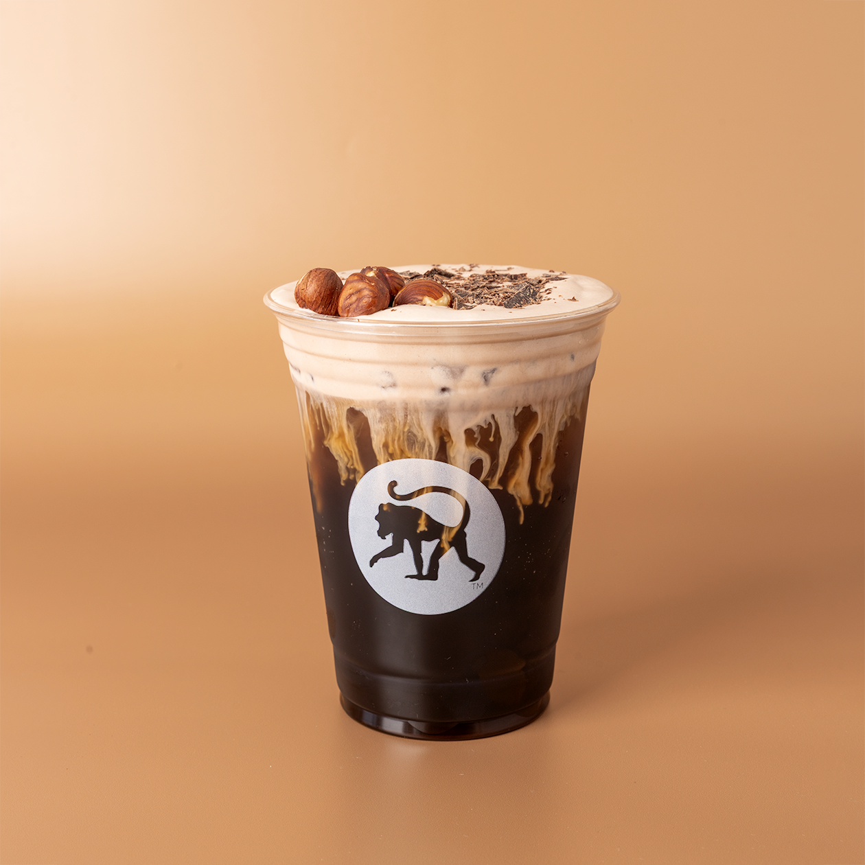 Nutella cold brew in a Frothy Monkey branded cup with chocolate drizzle, cold foam, whole hazelnuts, and shavings.