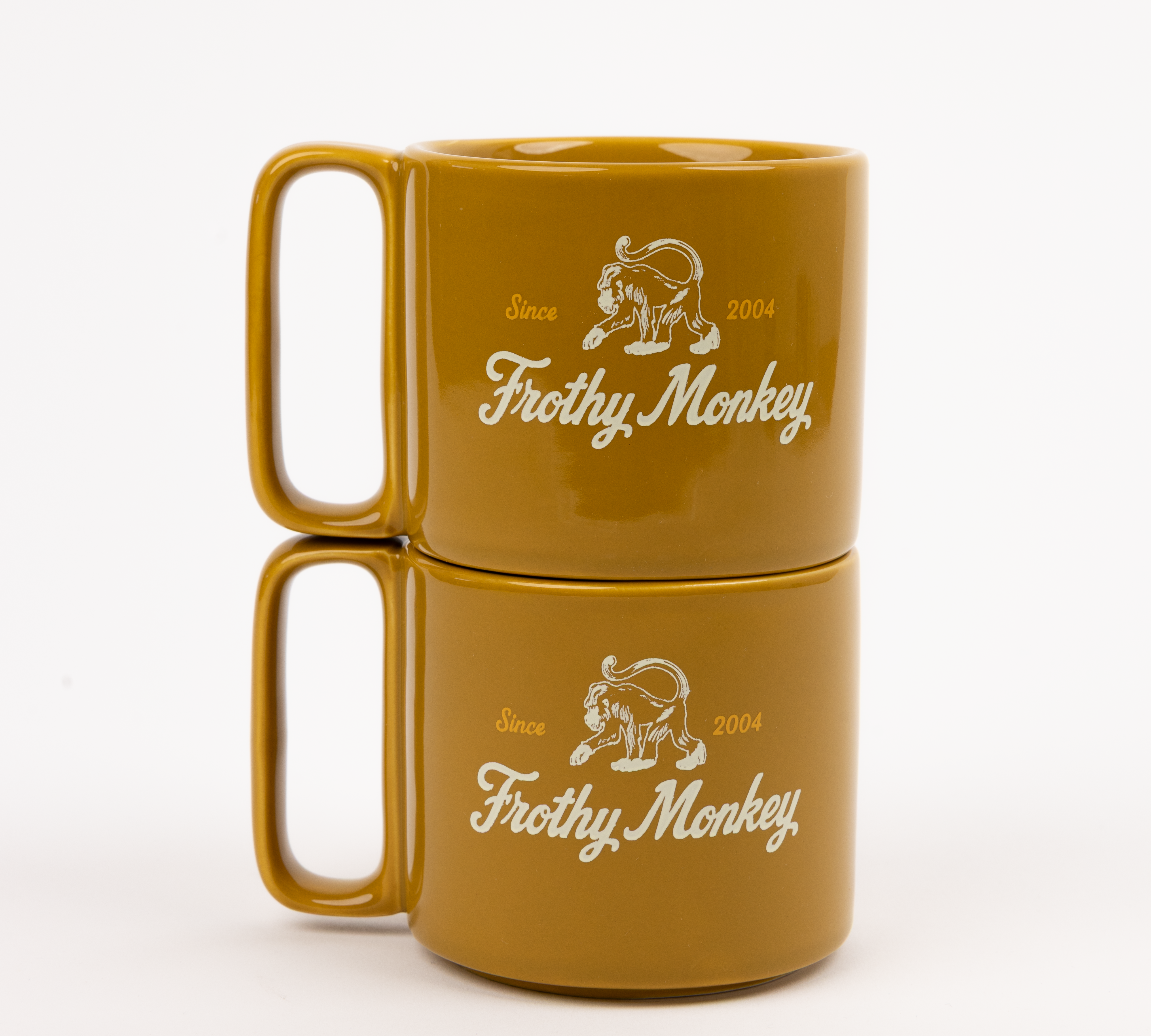 Two Frothy Monkey 10 oz stackable ceramic mugs in Chai stacked on top of each other, showing vintage Since 2004 monkey logo in cream with Brunch Yellow accents