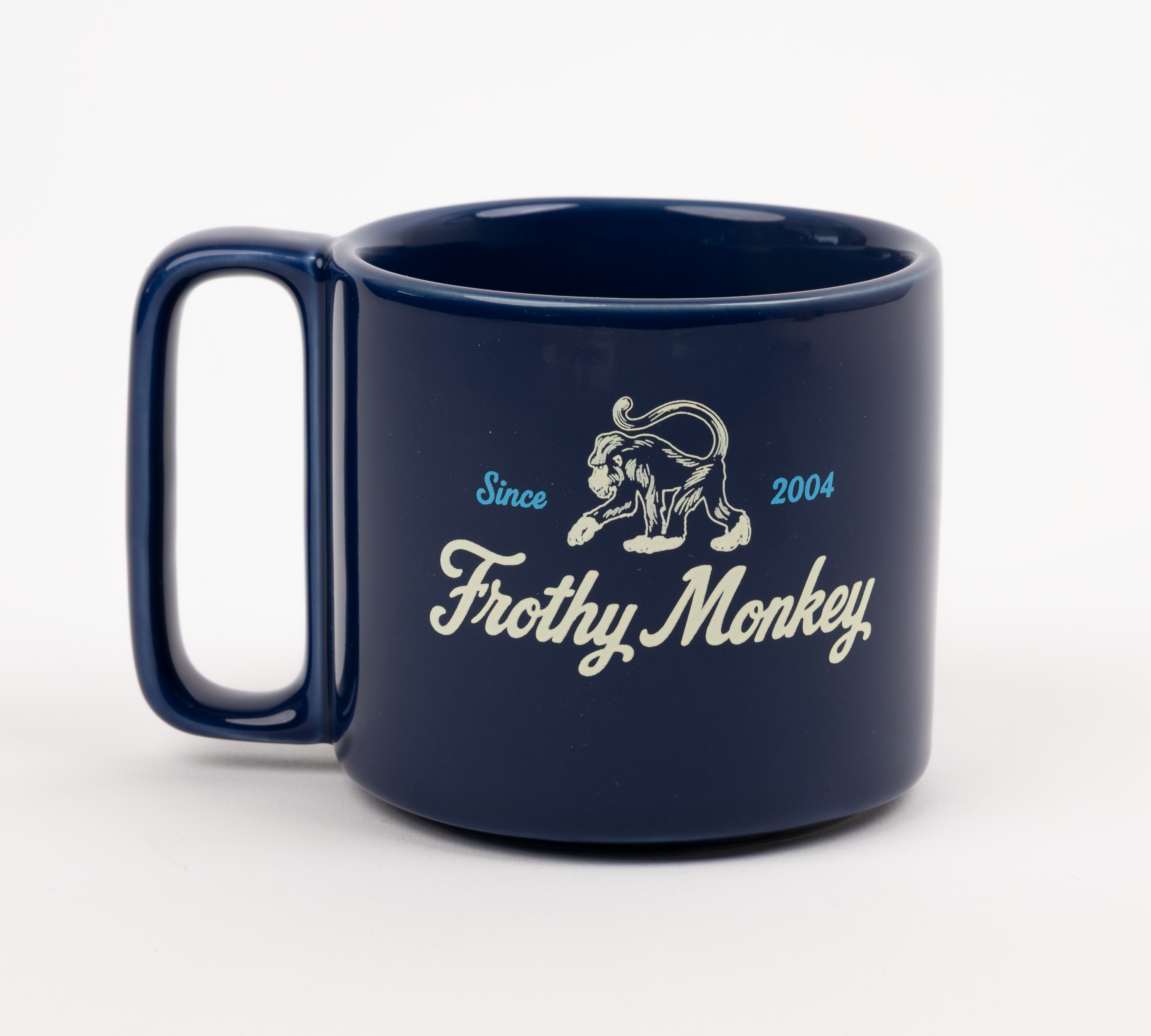 Single Frothy Monkey 10 oz stackable ceramic mug in Navy Blue with vintage logo in cream and Howler Blue accents, side view