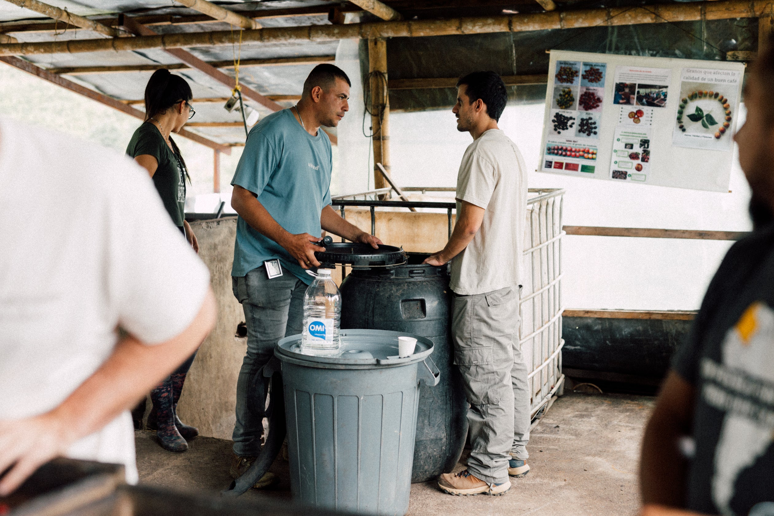 Andres Cardona talking with a visitor beside fermentation tanks at La Ilusion, Santa Barbara, Colombia