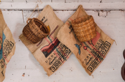 Woven cherry picking baskets hung on burlap coffee sacks at La Ilusion, Santa Barbara, Colombia