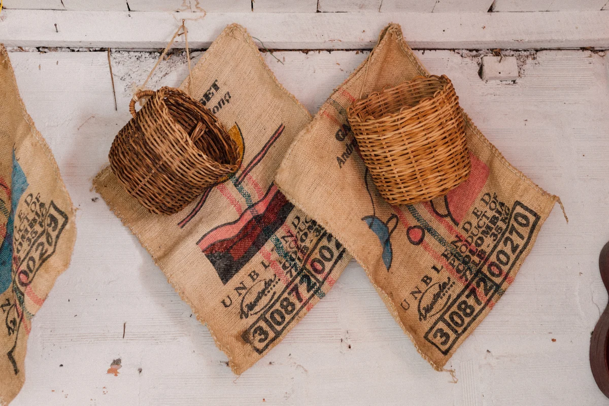 Woven cherry picking baskets hung on burlap coffee sacks at La Ilusion, Santa Barbara, Colombia