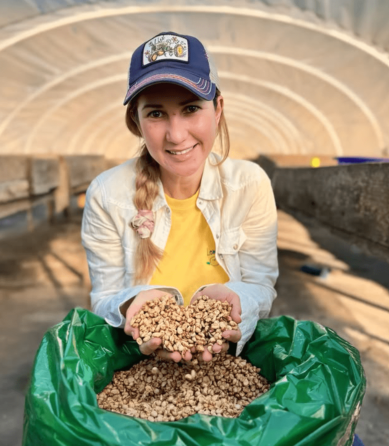 Producer Katia Duke holding parchment coffee in a drying greenhouse at San Isidro, Copán, Honduras